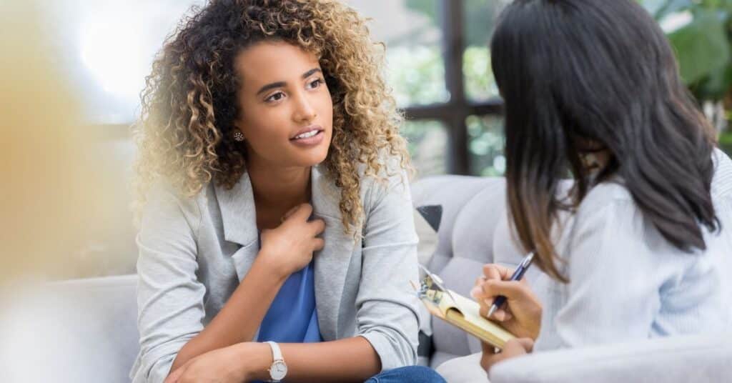 A woman speaks with a therapist during a counselling session